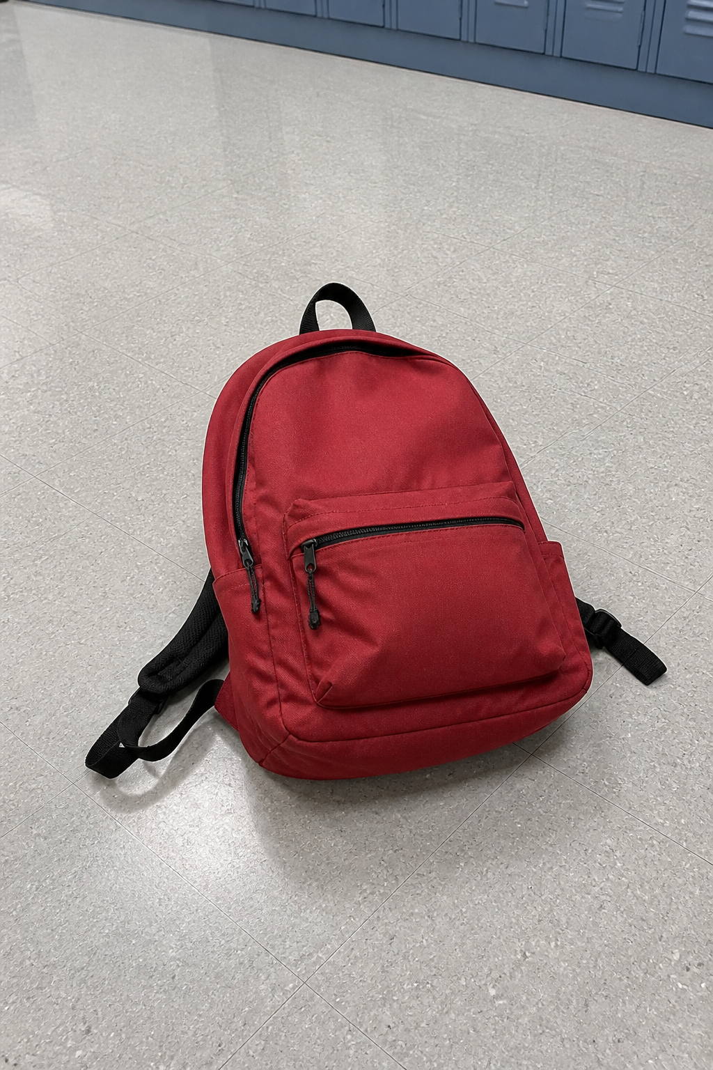 Red school backpack resting on a corridor floor through the phone camera